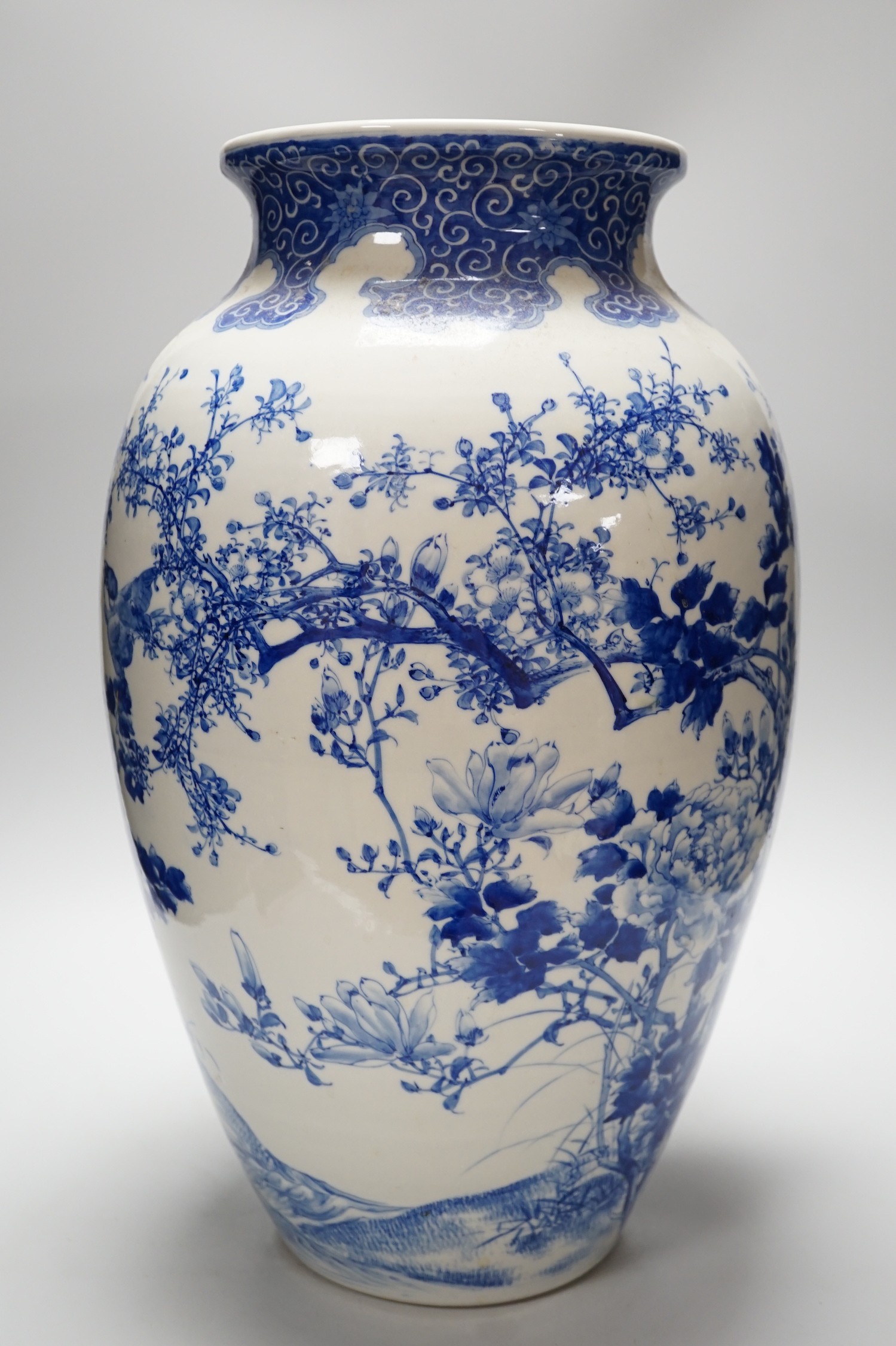 A large Japanese blue and white vase decorated with foliage and birds, 49cms high